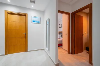 a hallway with a door and a bedroom at 2BR Retreat in Hivernage Center with Pool, Balcony & Parking in Marrakech