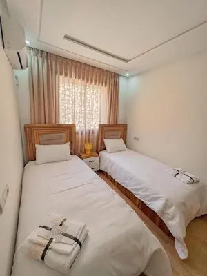 two beds in a room with a window at La perle de Marrakech in Marrakech
