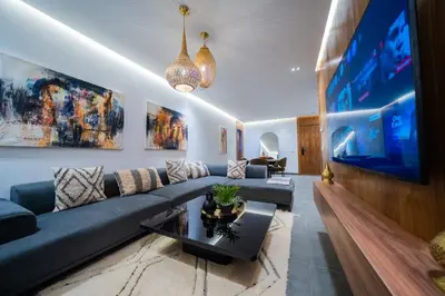 a living room with a blue couch and a large tv at Modern Moroccan Apartment in Gueliz with Terrace in Marrakech