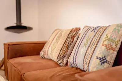 a brown couch with two pillows on it at Riad KECH LeS ESSENTIELS in Marrakech