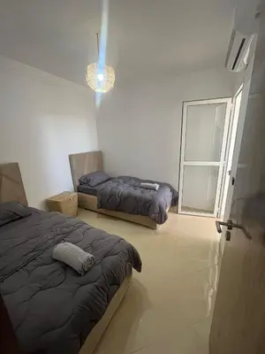 a bedroom with two beds and a window at Appartement 2 chambres meublé Marrakech in Marrakech