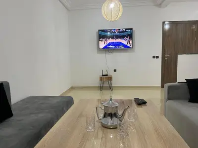 a living room with a coffee table and a tv at Appartement 2 chambres meublé Marrakech in Marrakech