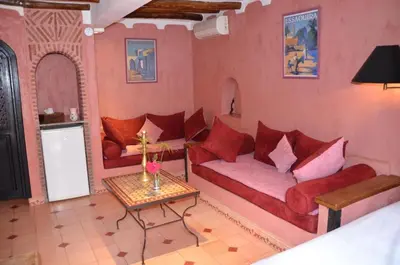 a living room with a red couch and a table at La casa de alma in Aït Hamid