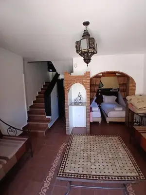 a living room with a staircase and a room with a couch at La casa de alma in Aït Hamid