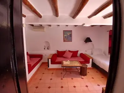 a living room with a red couch and a table at La casa de alma in Aït Hamid