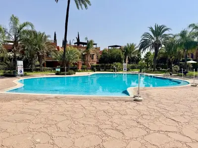 a large swimming pool in a resort with palm trees at Stylish Atlas Golf Resort Getaway - Free Breakfast, Rooftop Patio, Pool, Views in Marrakech