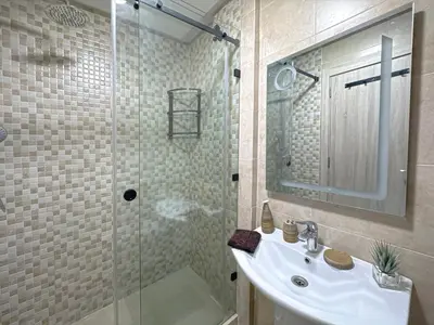 a bathroom with a sink and a glass shower at charming and cozy studio with swimming pool in Marrakech