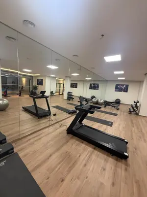 a gym with a row of treadmills and mirrors at Appartement Guéliz 2 piscines, jacuzzi chauffé et fitness in Marrakech