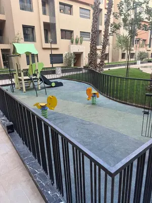 a playground in front of a apartment building with a playground at Appartement Guéliz 2 piscines, jacuzzi chauffé et fitness in Marrakech