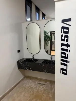 a bathroom with two sinks and two mirrors at Appartement Guéliz 2 piscines, jacuzzi chauffé et fitness in Marrakech