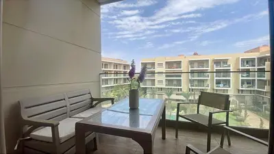 a balcony with a table and two chairs and a building at Luxury Pastel Suite with Balcony & Pool in Marrakech
