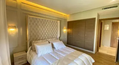 a bedroom with a large bed with white pillows at Luxury Pastel Suite with Balcony & Pool in Marrakech