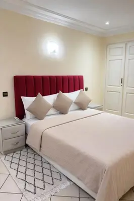 a bedroom with a large bed with a red headboard at Villa Sara in Marrakech