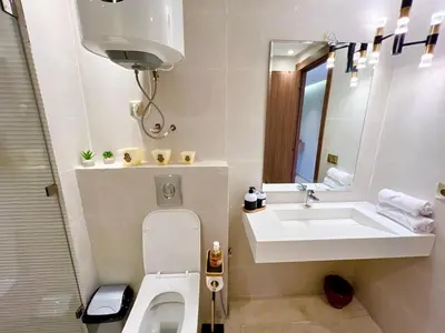 a bathroom with a sink and a toilet and a mirror at Modern Gueliz Suite - Balcony Views in Marrakech