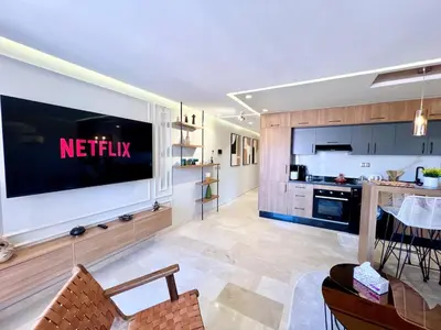 a living room with a large television on a wall at Modern Gueliz Suite - Balcony Views in Marrakech