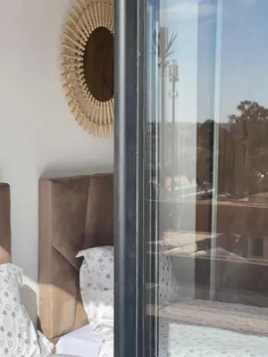 a mirror on a wall next to a window with a couch at Appart 2 chambres Gueliz in Marrakech