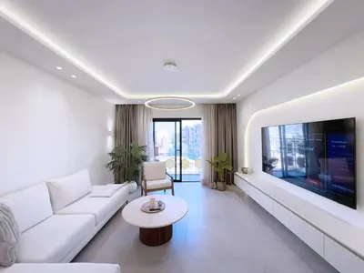 a living room with a white couch and a tv at Modern & luxurious apartment in Victor Hugo, Marrakech in Marrakech