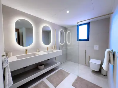 a bathroom with two sinks and a toilet and mirrors at Modern & luxurious apartment in Victor Hugo, Marrakech in Marrakech