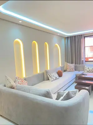 a living room with a large couch and yellow lights at Welcome to your peaceful getaway in Marrakech! in Marrakech