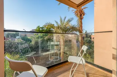 a balcony with two chairs and a view of a garden at Le Nahla - Centre - 4 Prs - Terrasse in Marrakech