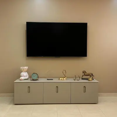 a flat screen tv on a wall with a dresser at Calme & Confort Mabroka - 2 chambre in Marrakech