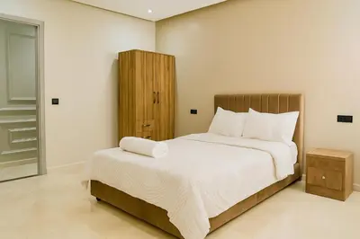 a bedroom with a large bed with white sheets at Calme & Confort Mabroka - 2 chambre in Marrakech