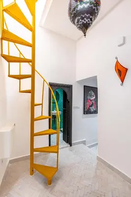 a wooden spiral staircase in a room with a hallway at Casa Coloré terrace and bohemian charm in Marrakech