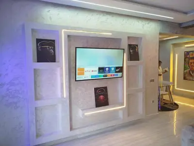 a wall with a flat screen tv on a wall at kech vacations 2 bedroom luxury gulize apartment in Marrakech