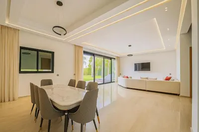 a dining room with a table and chairs and a couch at Argan golf in Marrakech