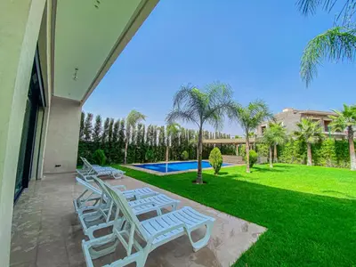 a patio with lounge chairs and a swimming pool at Argan golf in Marrakech