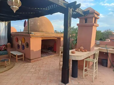 an outdoor patio with a table and a fireplace at Atlas golf resort beldi chic piscine in Marrakech