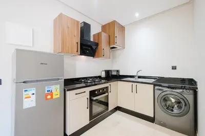 a kitchen with a refrigerator and a washer and dryer at Modern Studio with Pool in Marrakech