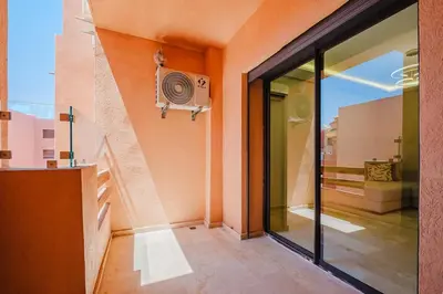 a house with a balcony with a speaker on the wall at Modern Studio with Pool in Marrakech