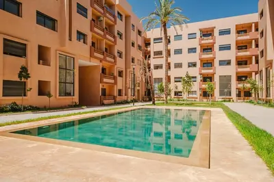 an apartment with a swimming pool in front of a building at Modern Studio with Pool in Marrakech