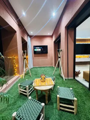 a living room with a table and green carpet at Chic Stay in Gueliz 1 in Marrakech
