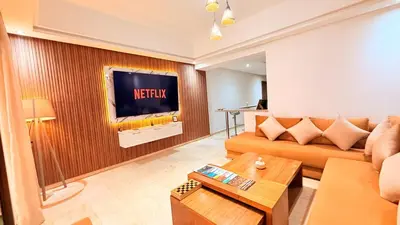 a living room with a couch and a television on a wall at Chic Stay in Gueliz 1 in Marrakech