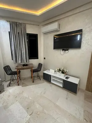 a living room with a tv and a table and chairs at 3wina immobilier in Marrakech