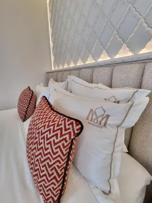 a pile of pillows sitting on a bed at Riad Dar Ninoun, Bassin chauffé & Petits déjeuners in Marrakech
