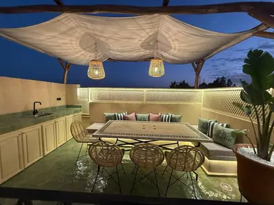 a patio with a table and chairs and a couch at Riad Dar Ninoun, Bassin chauffé & Petits déjeuners in Marrakech