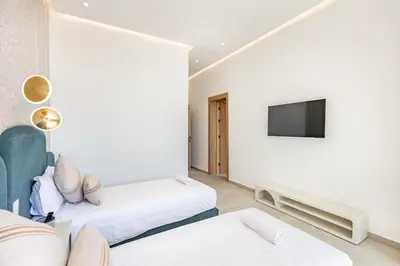 a hotel room with two beds and a tv at Spacious villa with jacuzzi and activities in Marrakech