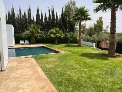 a backyard with a swimming pool and palm trees at Villa Zaara in Sehib Foukani