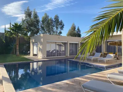 a swimming pool in front of a house at Villa Zaara in Sehib Foukani
