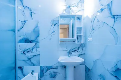 a blue bathroom with a sink and a mirror at Cosy & Modern Apartment Near Jardin Majorelle, Marrakech in Marrakech