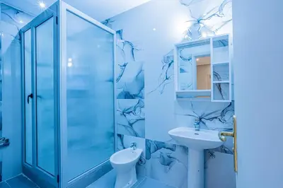 a bathroom with a glass shower and a sink at Cosy & Modern Apartment Near Jardin Majorelle, Marrakech in Marrakech