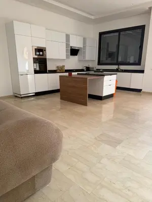 a living room with a couch and a kitchen at Villa Wissam in Marrakech
