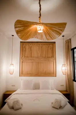 a bedroom with a large bed with a ceiling fan at Riad A l'Ombre du Palais in Marrakech