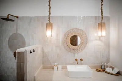 a bathroom with a white sink and a mirror at Riad A l'Ombre du Palais in Marrakech