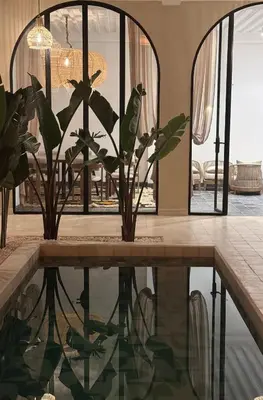 a room with a pool with two potted plants at Riad A l'Ombre du Palais in Marrakech