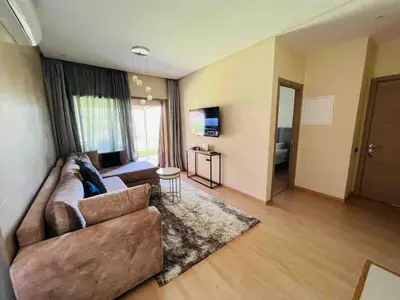 a living room with a couch and a television at Luxury Prestigia Golf City jade in Marrakech