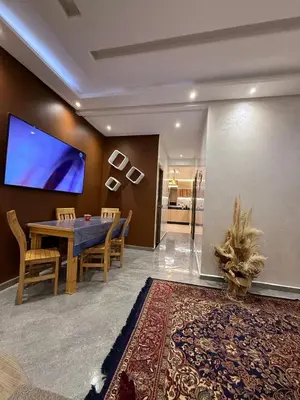 a dining room with a table and a large screen at appartement Jalal in Marrakech